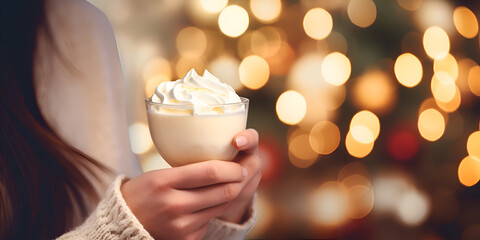 Close up of woman's hands  holding a eggnog drink at Christmas market, blurred background with lights  - obrazy, fototapety, plakaty