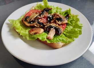 Appetizer with mushrooms, lettuce, tomato and sesame seeds