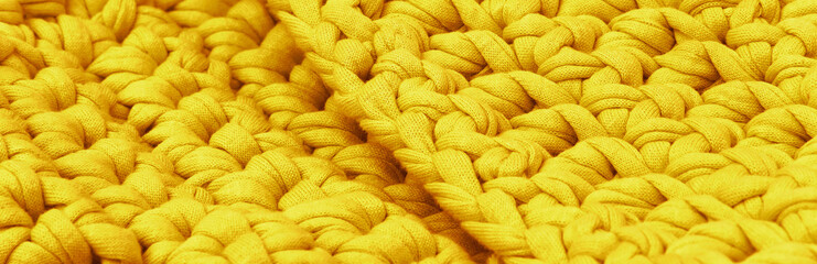 Yellow voluminous knitted background and texture. Side view. Panorama.