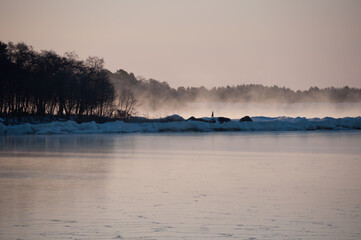 Obraz na płótnie Canvas A cold winter morning by the Gulf of Bothnia in Finalnd with fog rising from the open water