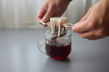 The process of brewing coffee. Water is poured into a drip coffee bag in a mug. Trends in brewing...