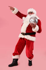 Cool Santa Claus with disco ball pointing at something on pink background