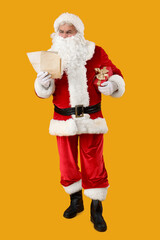 Santa Claus with letters and Christmas gift on yellow background