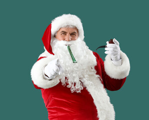 Cool Santa Claus with party blower and smoking pipe pointing at viewer on green background