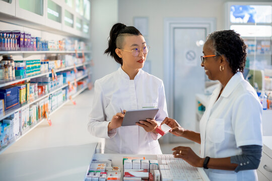 Pharmacist doing inventory with colleague in pharmacy