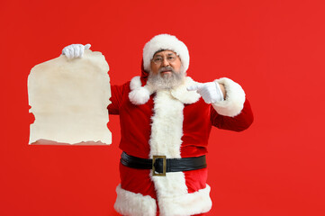 Santa Claus pointing at blank letter on red background
