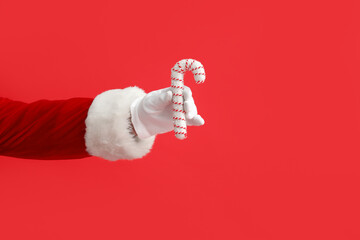 Santa Claus with candy cane on red background