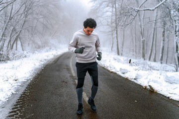 Warm up before going on a run in the foods on a snowy winter day, trees and ground are cover in snow