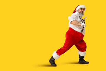 Fototapeta na wymiar Funny Santa Claus dancing on yellow background