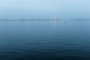 The early foggy morning on the river.  Foggy tranquil dawn scenery.