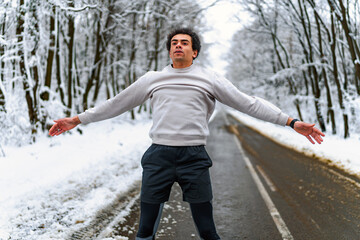 Man doing jumping jacks as a warmup before jogging on a winter day