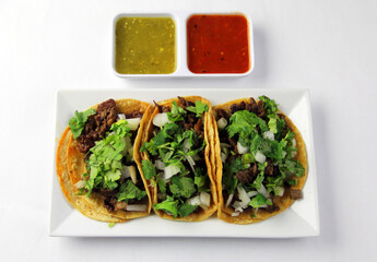 3 Steak Tacos on a Plate with Cilantro and Onion on Corn Tortilla Upper Top View