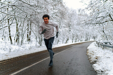 Man looking at his phone and sending text massages, there's snow covered scenery in the background