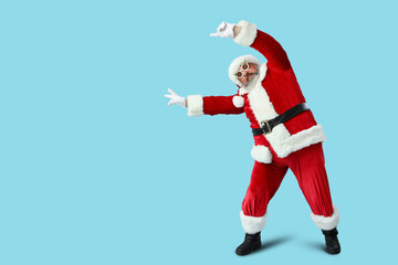 Funny Santa Claus dancing on blue background