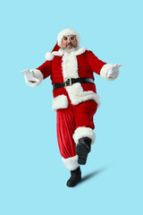 Funny Santa Claus dancing on blue background