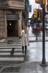 Casual woman at crosswalk with her dog. Gijón, Asturias
