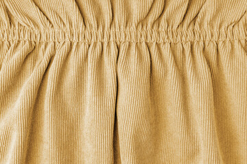 Yellow corduroy fabric gathered with elastic close-up. Velveteen texture with folds and drapery....
