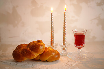 Challah bread, shabbat wine and candles on light background. Traditional Jewish Shabbat ritual. Shabbat Shalom.