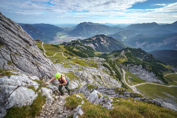 Eine Wanderin auf dem Klettersteig auf die Alpsitze. - obrazy, fototapety, plakaty