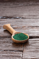 Organic spirulina powder in the wooden spoon - Healthy food