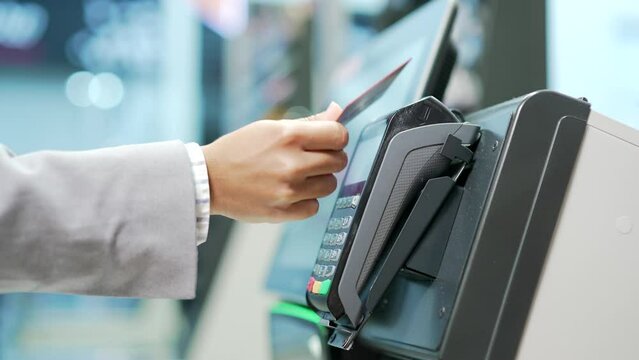 Close up Woman At Counter Buy electronic payment supermarket by credit card close-up. African american female hand pay for purchases in stores Contactless NFC Terminal Closeup card reader