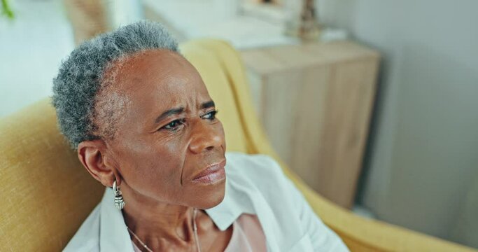 Thinking, nostalgia and sad senior black woman in a chair with memory or depression at nursing home. Remember, face and elderly African lady person in living room with dementia, Alzheimer or lonely