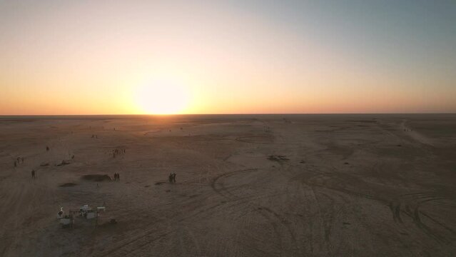 Low drone flight in a salt desert with a sunset. Drone flies forward at low level. General plane