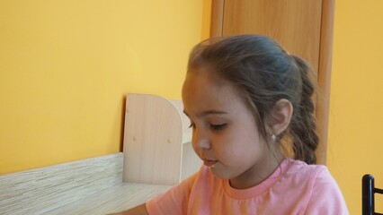 Fototapeta premium little happy girl eating carrot cake in a cafe. Happy child enjoying dessert and coffee with closed eyes, sitting in cafe. girl eating cake, spending time in cafeteria.