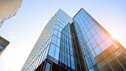Fototapeta na wymiar Looking up blue modern office building. The glass windows of building with aluminum framework.