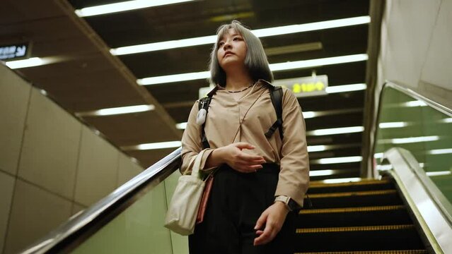 台北の都市部の地下鉄を歩く若い台湾人女性 Young Taiwanese woman walking on the subway in Taipei's urban area