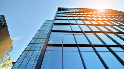 Looking up blue modern office building. The glass windows of building with  aluminum framework.