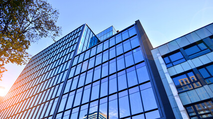 Looking up blue modern office building. The glass windows of building with  aluminum framework.