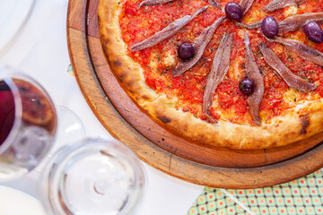 Pizza top view with close up with aliche and tomatoes