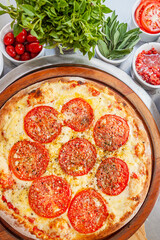 Margherita pizza top view with ingredients background close up basil tomatoes, onions