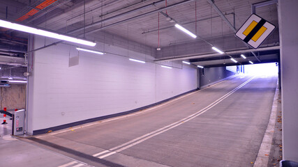 Underground parking under shopping center. Car parking garage with lighting and columns.