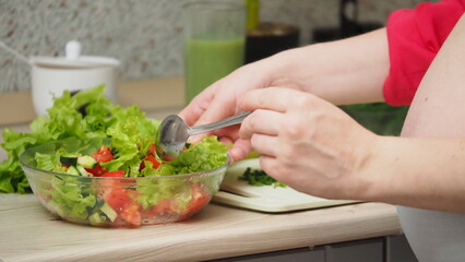 Beautiful Pregnant Woman Happily Preparing a Vegetable Salad, Organic Healthy Food, in a Cozy Home Kitchen. The Concept Of Diet, Proper Nutrition, Healthy Pregnancy and People.