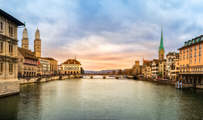 Panoramic view of Zurich city center, Switzerland. Zuerich old town with famous Fraumunster and Grossmunster Church on bank of river Limmat at sunset with dramatic sky in winter
