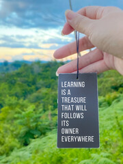 Inspirational life quote concept with blurred nature background - Learning is a treasure that will follow its owner everywhere

