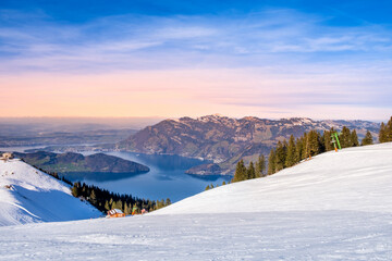 Klewenalp mountain and Lake Lucerne or Vierwaldstattersee at sunset. Mountains covered with snow. Popular ski resort in Swiss Alps and winter sport attraction in Switzerland in winter landscape - obrazy, fototapety, plakaty