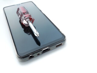 Smartphone repair concept with screwdriver on a screen