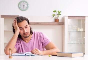 Young male student preparing for exams at home