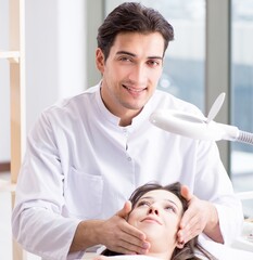 Obraz premium Young woman visiting male doctor cosmetologist