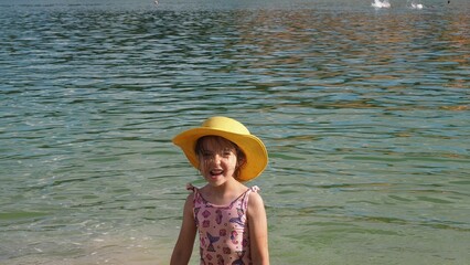 Boy and girl playing on the beach on summer holidays. Children in nature with beautiful sea, sand and blue sky. Happy kids on vacations at seaside running in the water