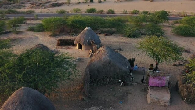 Drone shot of people and domestic animals with mud huts in Village of Sindh, Pakistan