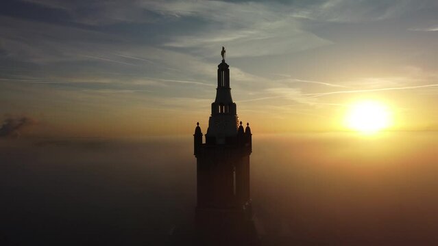 Ascending silhouette drone of St. Christopher Cathedral bell tower on sunset sky in Netherlands