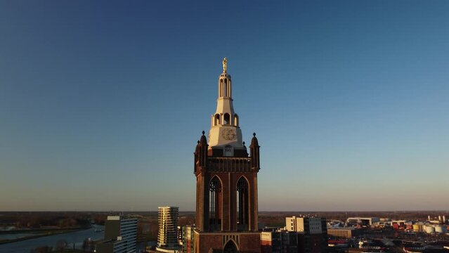 Drone footage of the bell tower of Saint Christopher's Cathedral against dusk sky in Roermond