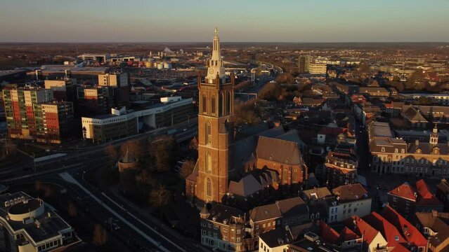 Drone footage of Saint Christopher's Cathedral and the cityscape of Roermond town at sunset