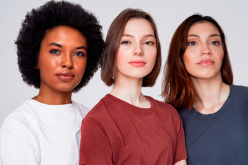 Portrait of three women of different ethnic groups wearing T-shirts of different colours
