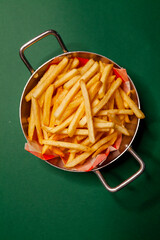 French fries dish top view close up green background