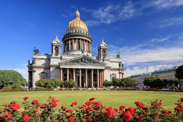 Stunning St. Isaac's Cathedral surrounded by vibrant red roses against a bright blue sky